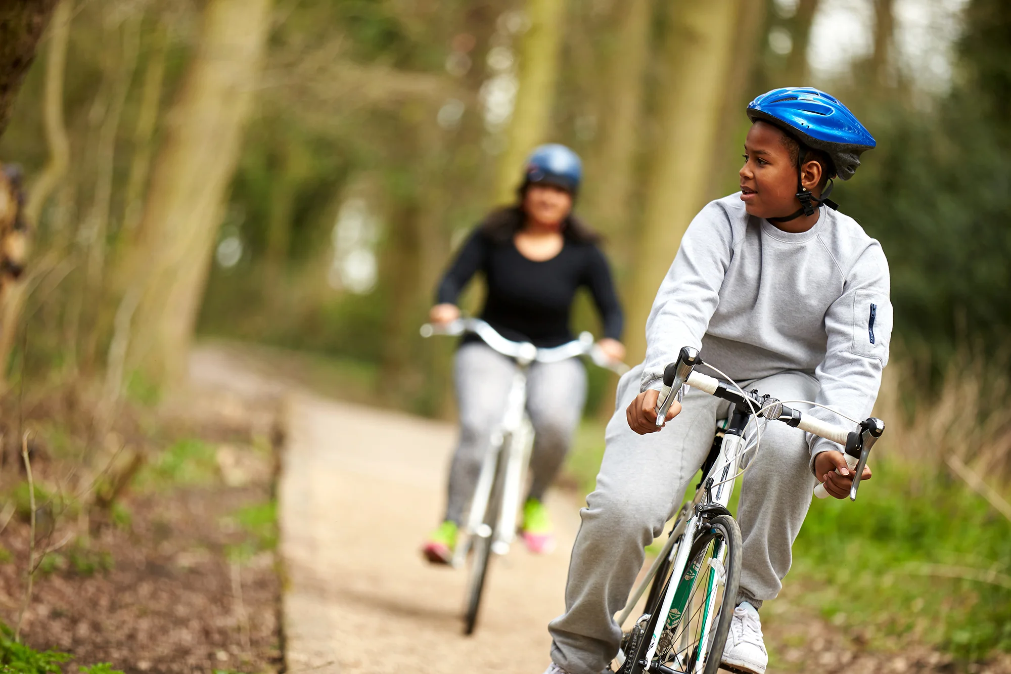 Teenage boy and mum on bikes in the wood