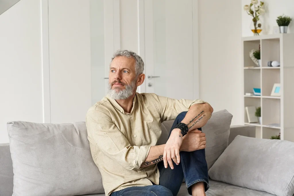 Older man sat on sofa