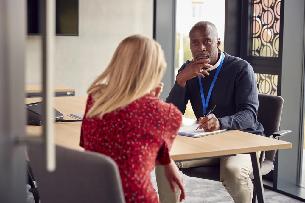 Man and woman talking at a desk