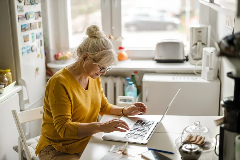 Woman using laptop in her kitchen