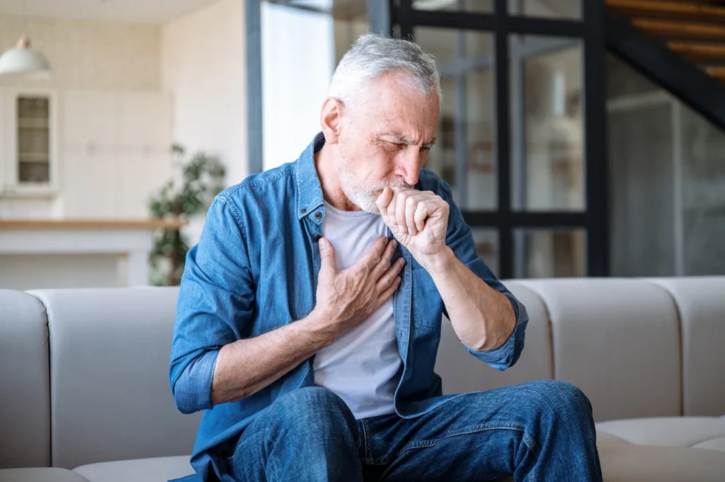 Man coughing and holding chest