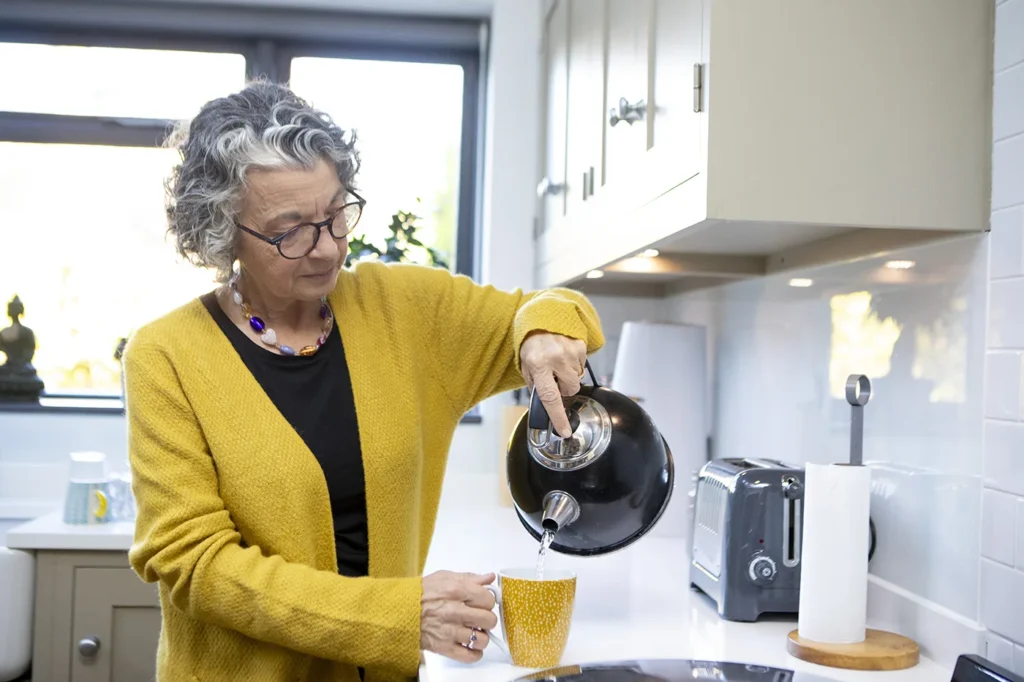 Older lady making a cup of tea
