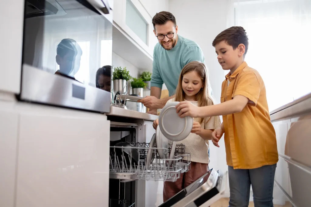 Man and children loading dishwasher