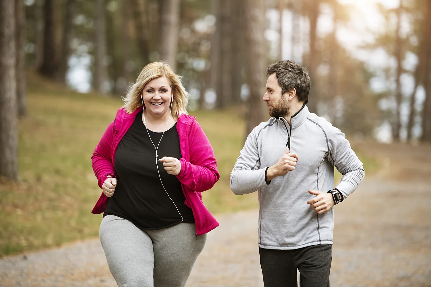 Overweight woman jogging with a trainer