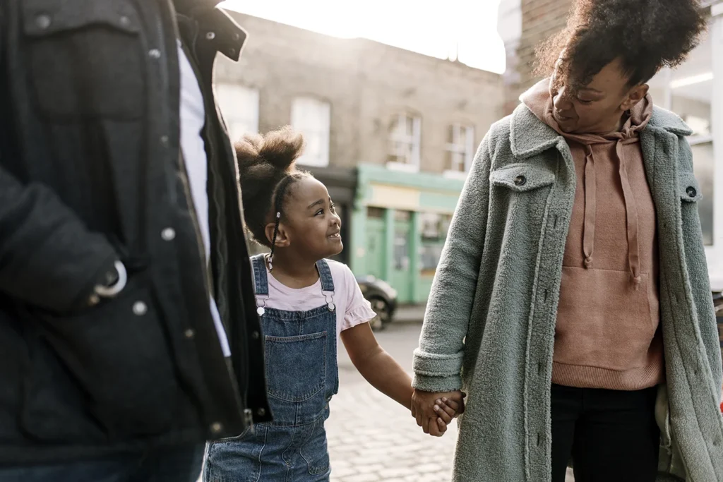 Couple holding hands with their daughter