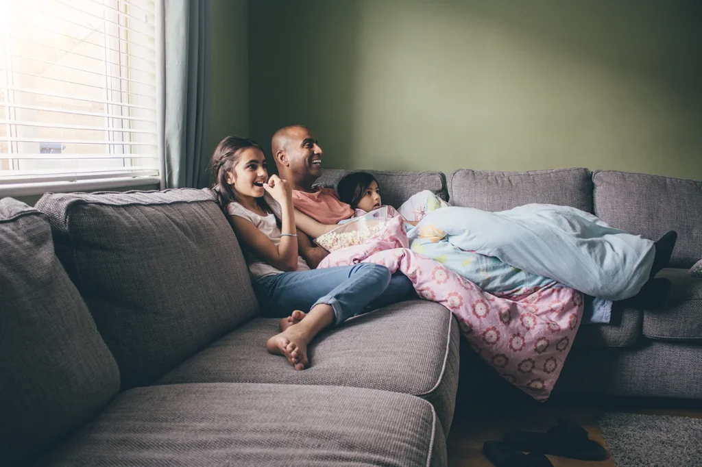 Family watching TV on sofa