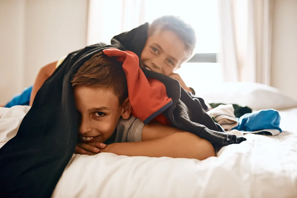 Children playing on a bed