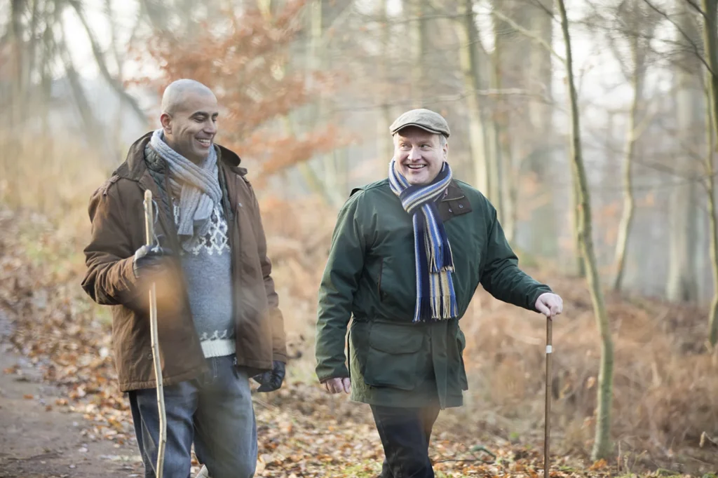 Two older men walking in woods