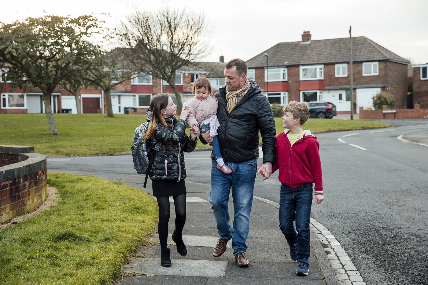 Father and children walking home from school