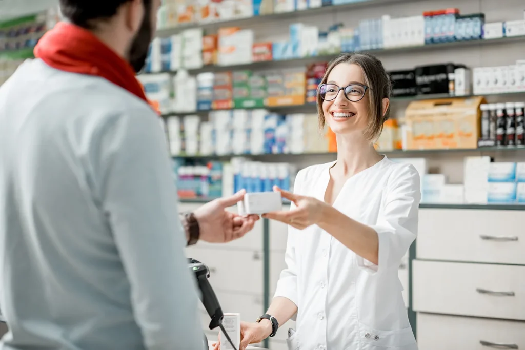 Pharmasist handing package to customer