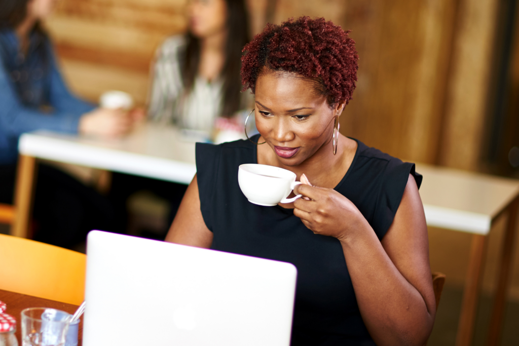 Woman sitting in a coffee shop, with her laptop.
