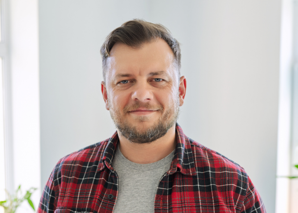 An image of a 45 year old man, smiling to camera.